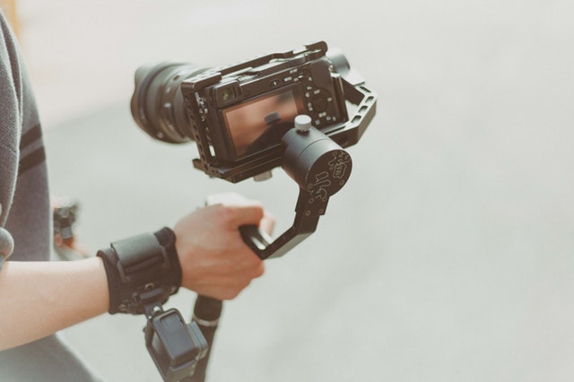 hand holding a gimbal onto a camera