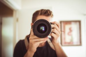 man taking a selfie with a canon video camera