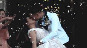 bride and groom kissing with confetti in the foreground