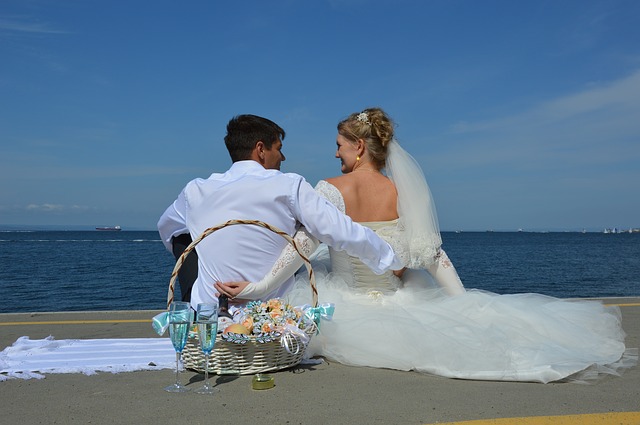 bride and groom sitting at the beach