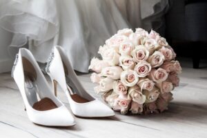 white wedding shoes with pink bouquet