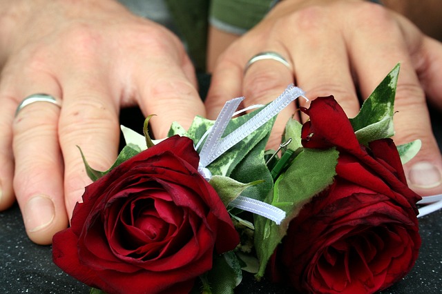 bride and groom rings with red roses