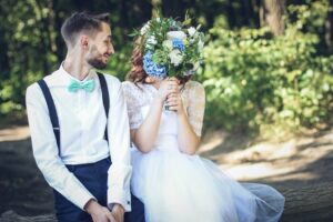 bride covering face with white bouquet