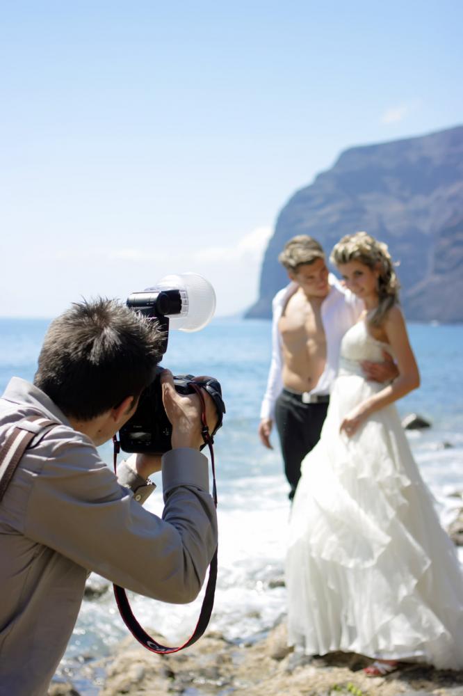 bride and groom on beachwith photographer 