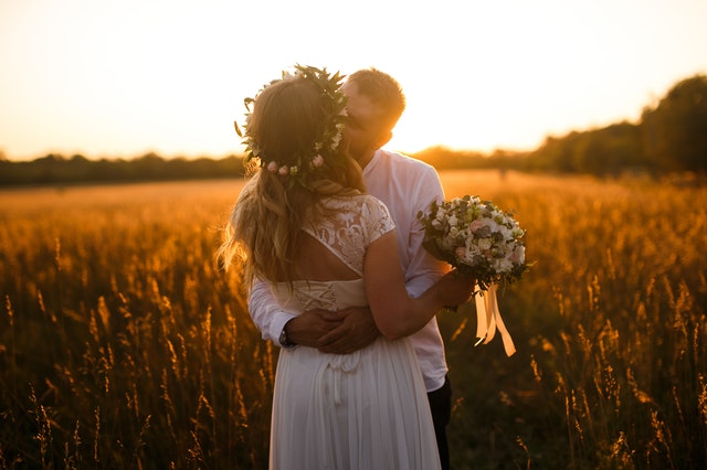 bride and groom kissing sunset
