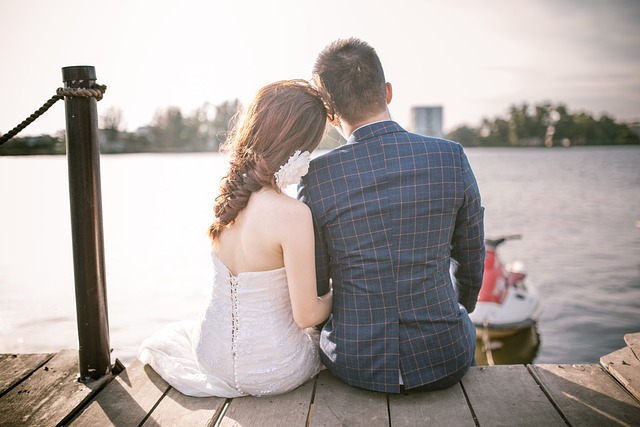 bride and groom sitting at beach 