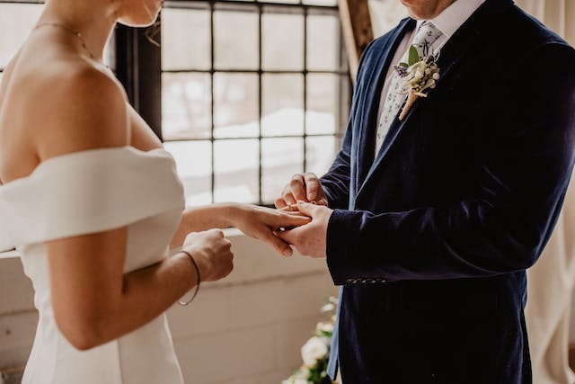 Groom giving ring to bride